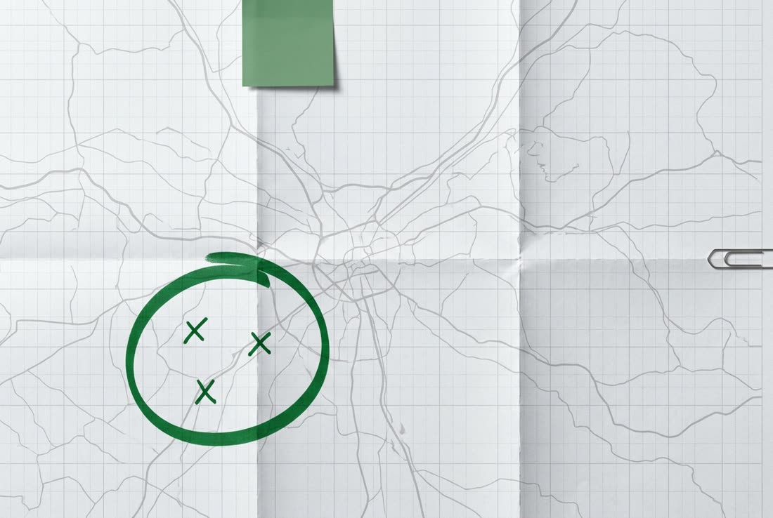 Une carte routière pliée, un secteur entouré au feutre vert, trois croix à l’intérieur.
